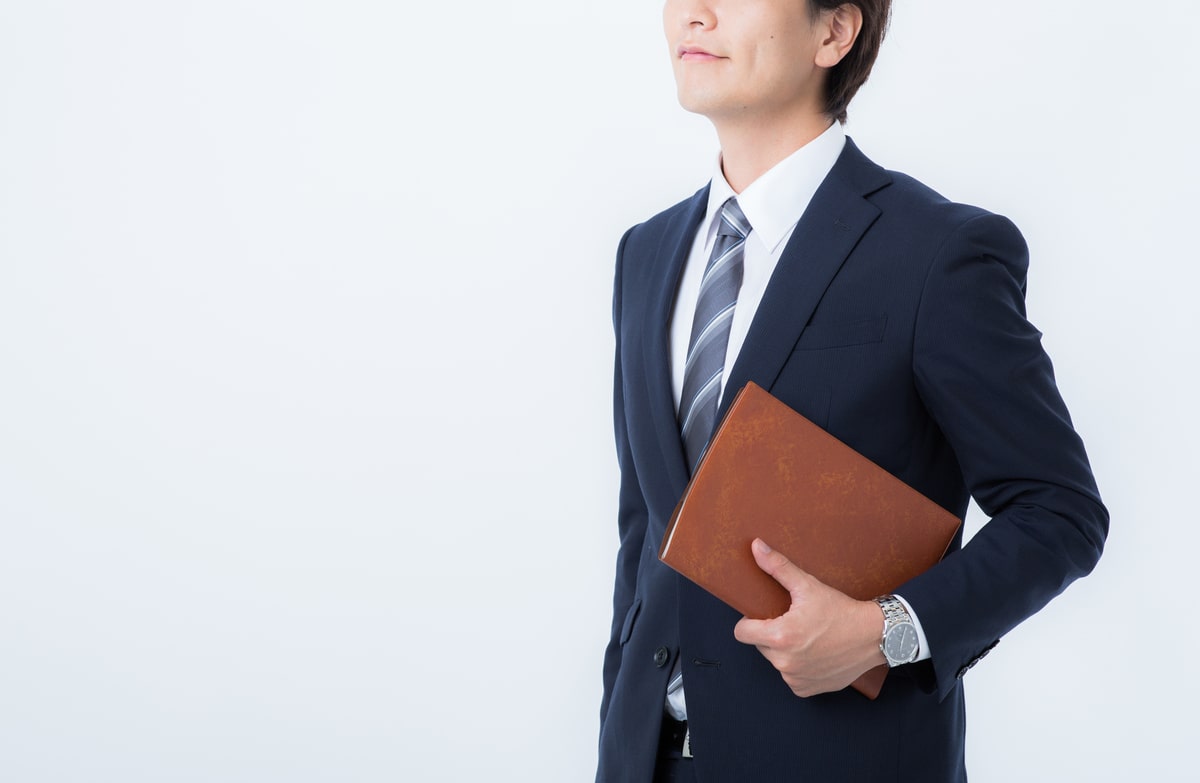 片手に本を抱える男性