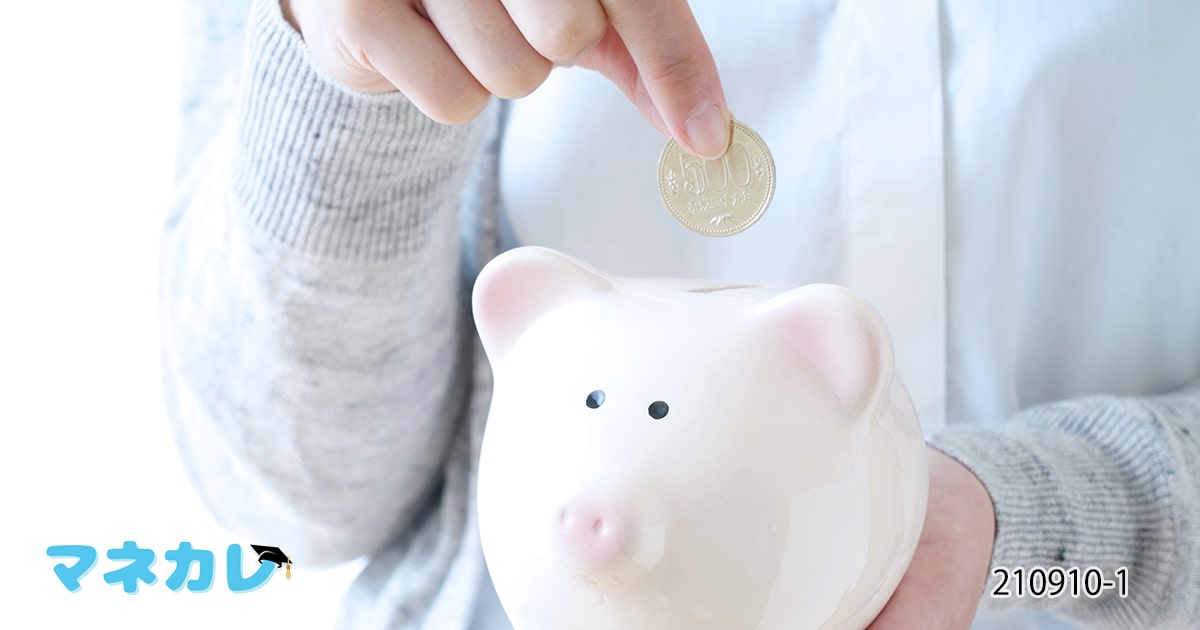 豚の貯金箱に投入される500円玉