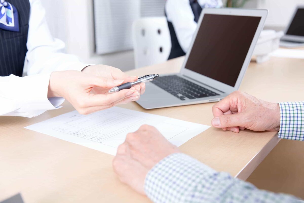 ペンを渡す証券会社の受付女性
