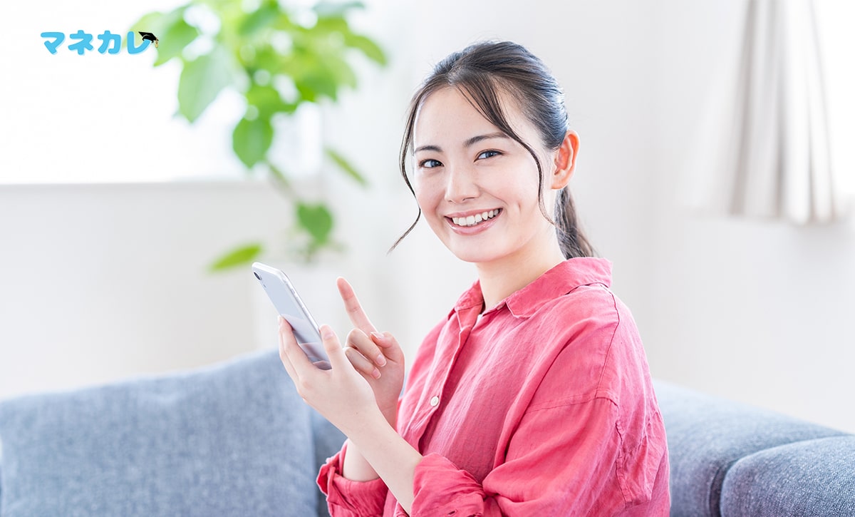 スマートフォンを持って笑う女性
