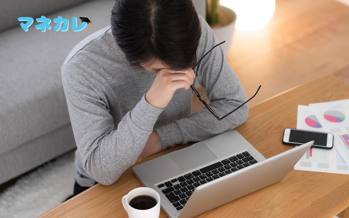 パソコンの前で悩む男性