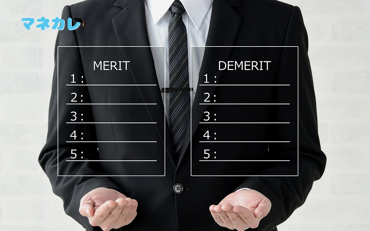 メリットとデメリットが書かれたボードを持つ男性