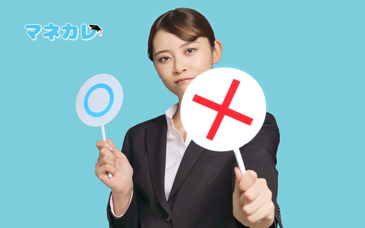 マルバツの札を持った女性